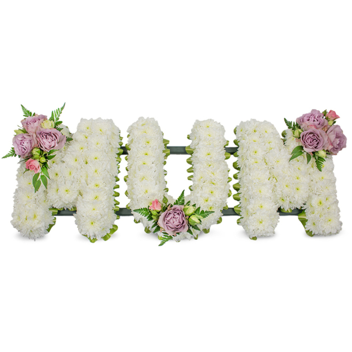 A meticulously hand-crafted sympathy display spells the word MUM in full capital letters, each letter densely enrobed with hundreds of fresh white chrysanthemums that read like a soft, pristine blanket of petals. The chrysanthemums' tiny heads are tightly packed to form a clean, sculptural surface that both soothes the eye and suggests peaceful remembrance. Three small, artful clusters of accent roses in muted lavender and pale pink sit at carefully chosen points - on the upper left arm of the first M, in the central curve of the U, and atop the upper right arm of the final M - with each cluster combining fully opened roses, gentle buds and glossy green leaves. Fine fern fronds and lighter green filler foliage weave through these accents, creating depth and a natural rhythm that lifts the arrangement away from the white background. A discreet dark green structural base - likely ribbon-wrapped wire or mossed foam - is visible along the lower edge and between letters, anchoring the arrangement while remaining sympathetic to the overall palette. Photographed in soft, even lighting, the composition radiates calm and restraint; the whites read as pure and luminous, while the lavender and blush notes lend tenderness and warmth. As a local florist serving Cobham - from the High Street to Painshill Park and the riverside near the Mole - Flower Delivery Cobham often prepares this style of tribute for funeral services, memorials or graveside dedications, where families request a classic, dignified expression of love and remembrance for a mother. The piece is designed to convey comfort, respect and a lasting memorial in equal measure.