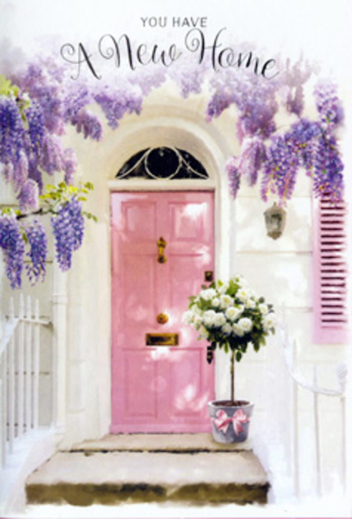 This doorway vignette evokes the calm elegance of a Cobham home, perhaps nestled along a quiet residential road near Painshill Park or one of the village's tree-lined avenues. A pastel pink front door forms the focal point, its smooth surface and carefully painted panels reflecting subdued daylight in a way that feels both fresh and soothing. The door is set within whitewashed walls, their subtle imperfections softly highlighted by the filtered light, and accompanied by a single pale shutter that hints at sunlit windows just beyond view. Draped overhead is a generous flourish of wisteria, the blossoms spilling in loose clusters of lavender and soft purple, each raceme heavy with imagined scent. The wisteria forms a natural arch above the entrance, its tendrils and leaves casting delicate, dappled shadows that dance across the frame. At ground level, on the stone step, stands a modest yet elegant grey metal bucket serving as an impromptu vase. It brims with creamy white roses, their petals plush, round, and invitingly open, mixed with sprigs of fresh green foliage that soften the silhouette and add texture. A light pink ribbon encircles the bucket, tied in a simple, graceful bow that connects the blooms visually to the pink door. The overall mood is one of quiet celebration-the kind of floral gesture chosen to mark a move into a new Cobham home, comforting yet refined. It is easy to imagine these flowers having just arrived via same-day delivery, offering congratulations, welcome, and a sense of serenity to whoever is about to cross the threshold for the very first time.