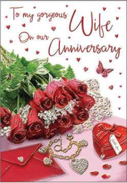 The composition of this anniversary card feels like a private love letter brought to life, perhaps resting on a polished sideboard in a Cobham townhouse. A small posy of crimson roses, each bloom tightly furled and richly coloured, dominates the foreground. The petals twist and swirl in layered spirals, catching soft highlights that make them appear almost tangible, as if you could lean in and touch their velvety surfaces. Around them, plush ferns and fresh greenery add contrast and vitality, echoing the lush arrangements created by experienced Cobham florists for romantic occasions. Scattered across the background are thoughtful details: a scarlet jewellery box tied with a ribbon sits invitingly open or closed; a golden necklace shaped like intertwined hearts catches the light, its curves echoing the form of the rose petals; and tiny sparkling decorations, like miniature jewels or sequins, reflect points of brightness across the card. The message on the card is written in a flowing, affectionate script, gently drawing the gaze as it winds among a cascade of tiny red hearts. Soft, even lighting floods the scene with warmth, creating a sense of intimacy and stillness, as though this arrangement has been prepared in anticipation of an evening celebration at home or in a favourite Cobham restaurant. Everything about the image speaks of enduring devotion and shared futures, from the opulent roses to the symbolic heart-shaped jewellery, suggesting that each anniversary builds on a foundation of cherished memories.
